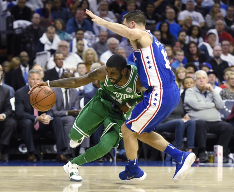 Boston's Kyrie Irving, left, drives to the basket past Philadelphia's T.J. McConnell in the first half Friday night in Philadelphia.