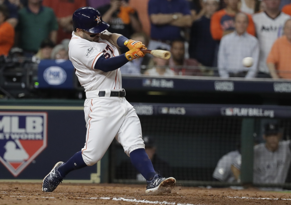 Houston's Jose Altuve hits a two-run single in the fifth inning Friday night in Game 6 of the ALCS at Houston.