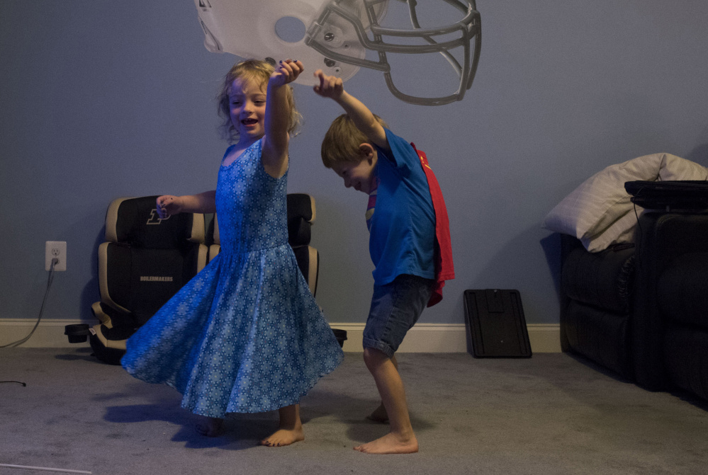 Alyssa Schlomer, 3, dances with her twin brother, Logan, at the Schlomer family's home in Lexington Park, Md.
