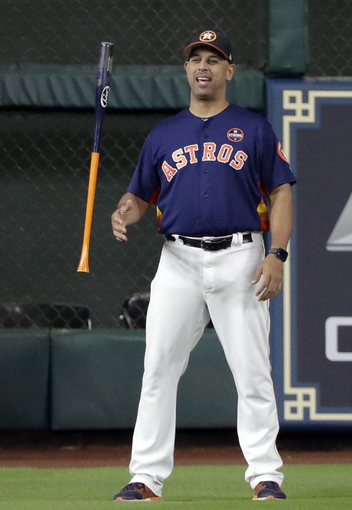 Houston bench coach Alex Cora flips a bat before Game 6 of the ALCS in Houston. The Boston Red Sox hired Cora to be their new manager.