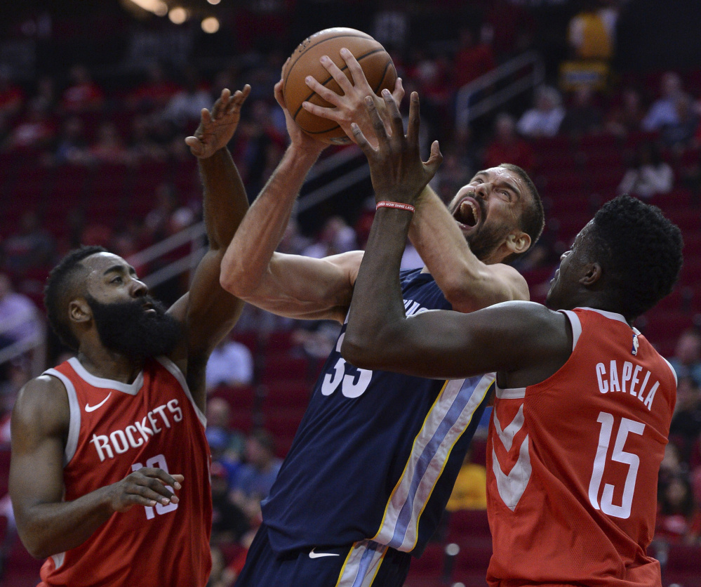 Marc Gasol of the Memphis Grizzlies looks for room Monday night while being guarded by James Harden, left, and Clint Capela of the Houston Rockets during the first half of Memphis' 98-90 victory on the road.