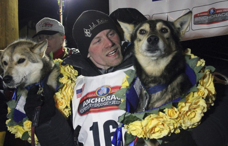 Dallas Seavey poses with his lead dogs Reef, left, and Tide after finishing the Iditarod Trail Sled Dog Race in Nome, Alaska. The four-time champion denies he administered banned drugs to his dogs in this year's race, and has withdrawn from the 2018 race in protest.