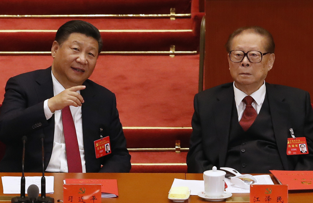 Chinese President Xi Jinping, left, chats with former President Jiang Zemin on Tuesday during the closing ceremony for the 19th Party Congress at the Great Hall of the People in Beijing. Despite his new status as China's most powerful ruler in decades, Xi lacks the broad popular support of the Chinese public, an analyst says.