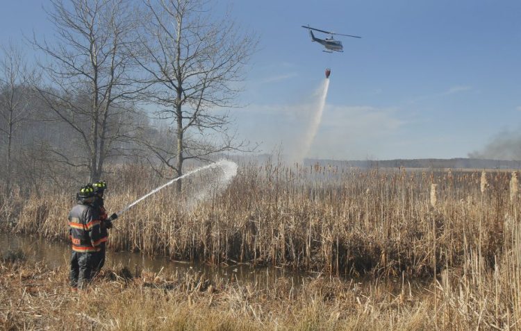 Firefighters battle a brush fire in Old Orchard Beach on April 15, 2016, that was fanned by strong wind. Ricky Plummer, who was the town's fire chief at the time, pleaded guilty Wednesday to setting the fire.