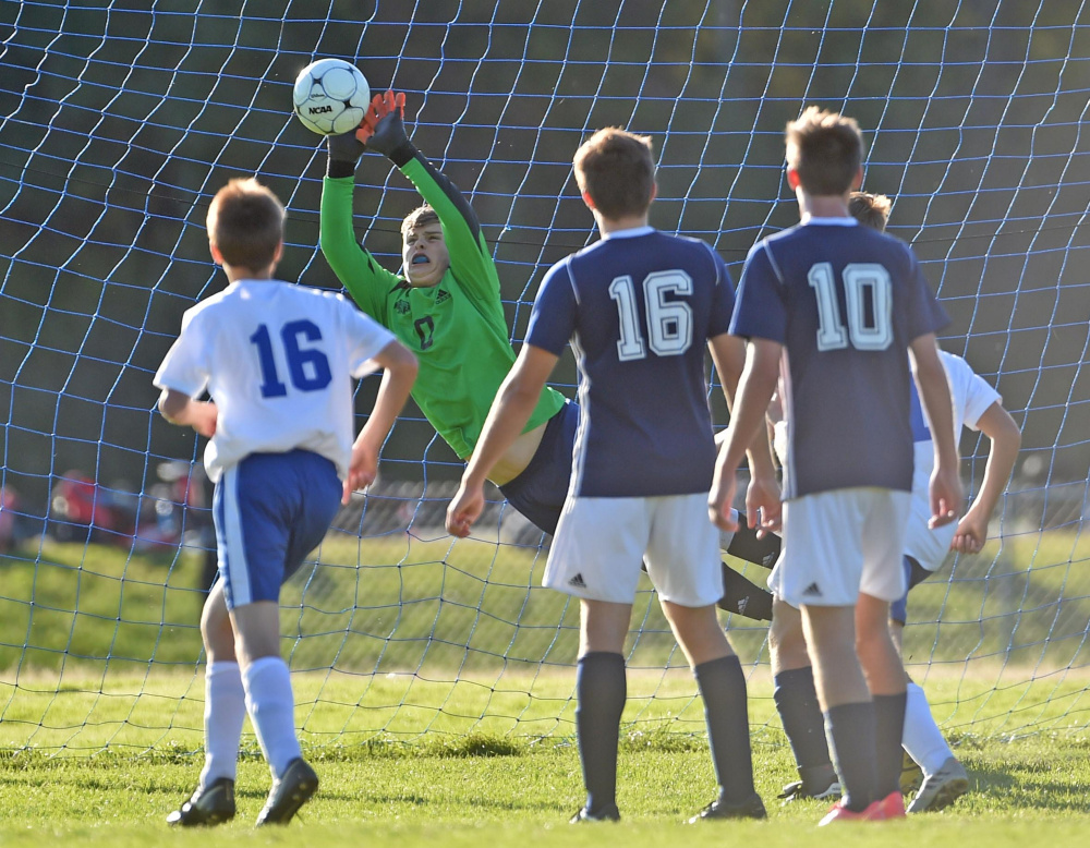 Mt. Blue goalie Tucker Carleton makes a save against Messalonskee High School in Oakland earlier this season as Dom Giampietro (16) and Alden Thompson Vought (10) look on.