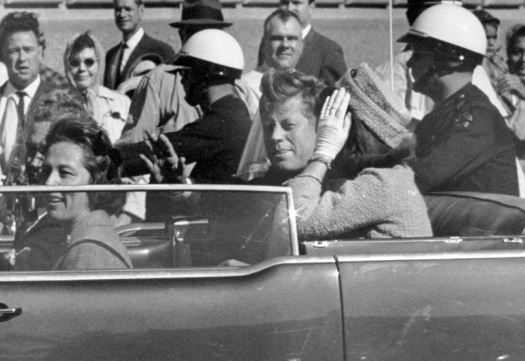 President John F. Kennedy waves from his car in a motorcade in Dallas on Nov. 22, 1963, just before his assassination. Riding with Kennedy are first lady Jacqueline Kennedy, right, Nellie Connally, second from left, and her husband, Texas Gov. John Connally, far left. President Trump released thousands of never-seen government documents related to the assassination on Thursday, but withheld others.