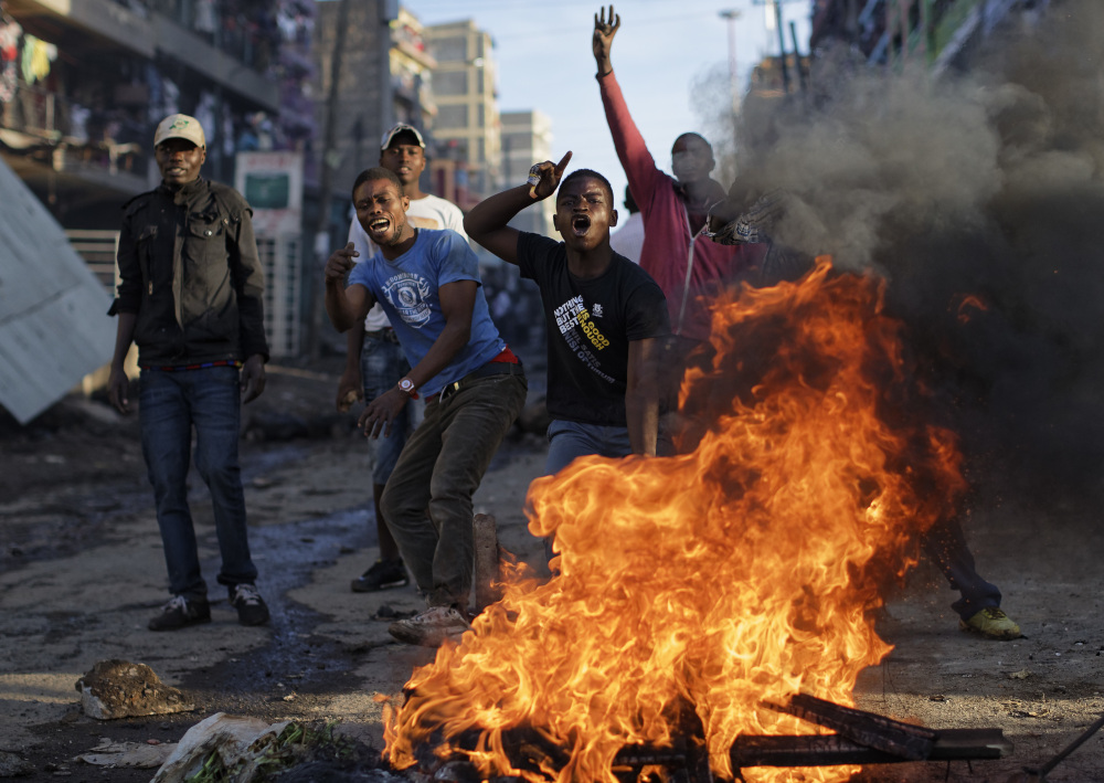 Opposition protesters taunt riot police to come and get them, as they stand behind a burning barricade during clashes in the Mathare slum of Nairobi, Kenya, on Thursday.