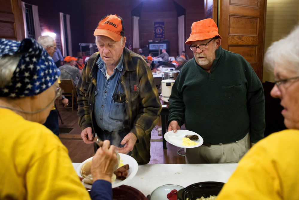 Wayne Weeks, left, and Steve McDuffie fill up their plates Saturday during the hunter's breakfast in St. Albans. 