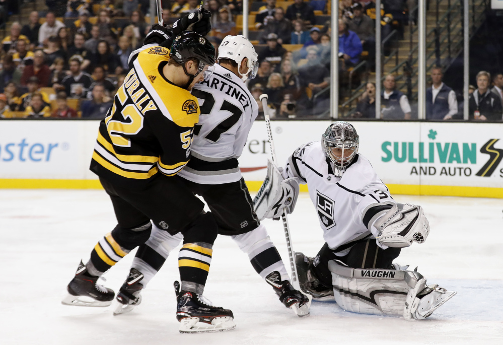 Los Angeles Kings goalie Jonathan Quick makes a glove save as Bruins' Sean Kuraly looks for a rebound during the second period in Boston on Saturday.