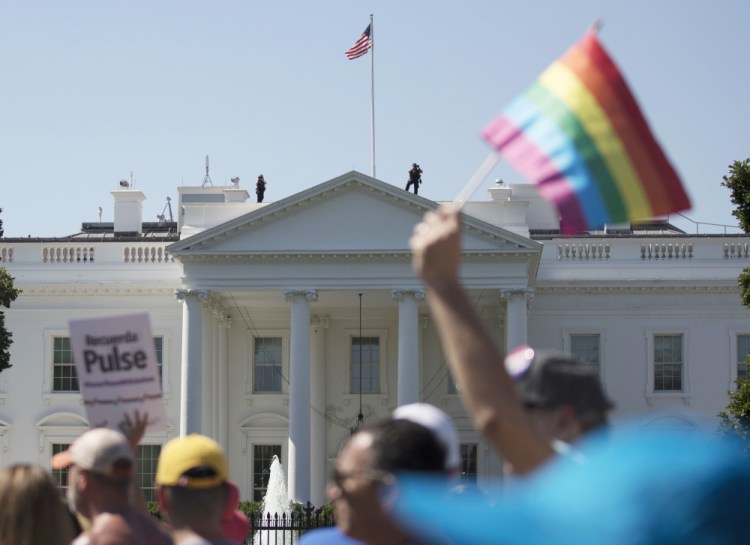 Equality March for Unity and Pride participants march past the White House on June 11.            A federal judge has halted plans to exclude transgender people from military service.