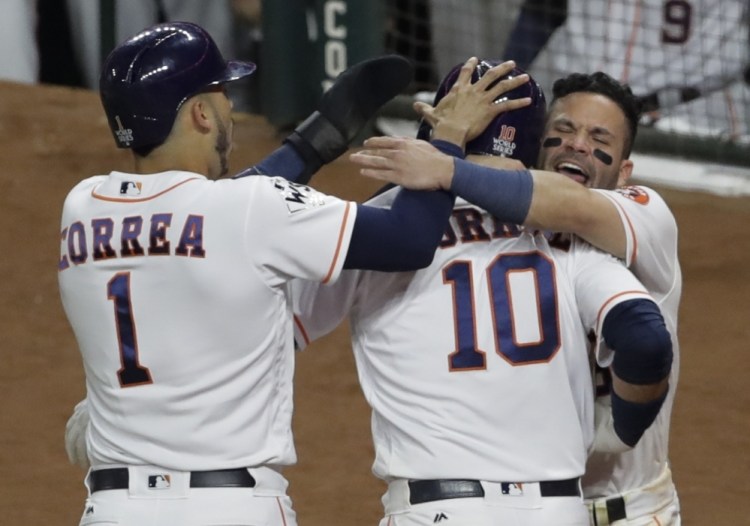 Houston's Yuli Gurriel is congratulated after hitting a three-run home run in the fourth inning of Game 5, which the Astros finally won 13-12 in the 10th inning early Monday morning.