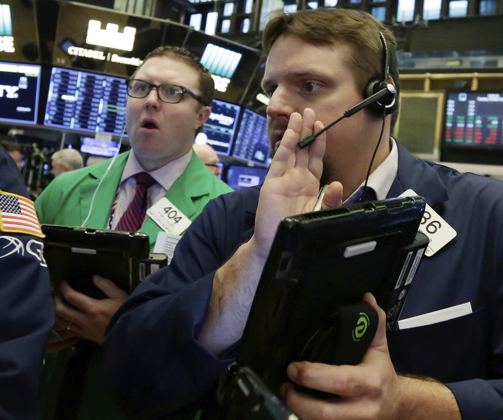 Two traders work Tuesday at the New York Stock Exchange, which has been energized by strong company earnings.