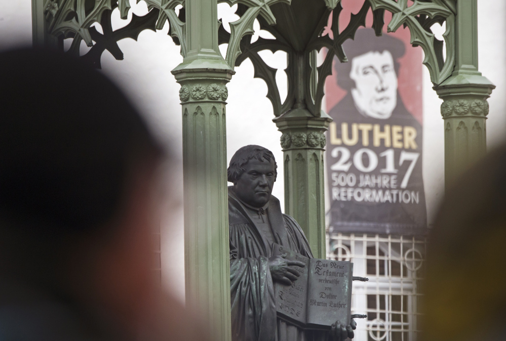 Visitors walk in front of the Martin Luther monument prior to celebrations marking the 500th Anniversary of the Reformation in Wittenberg, Germany, on Tuesday.