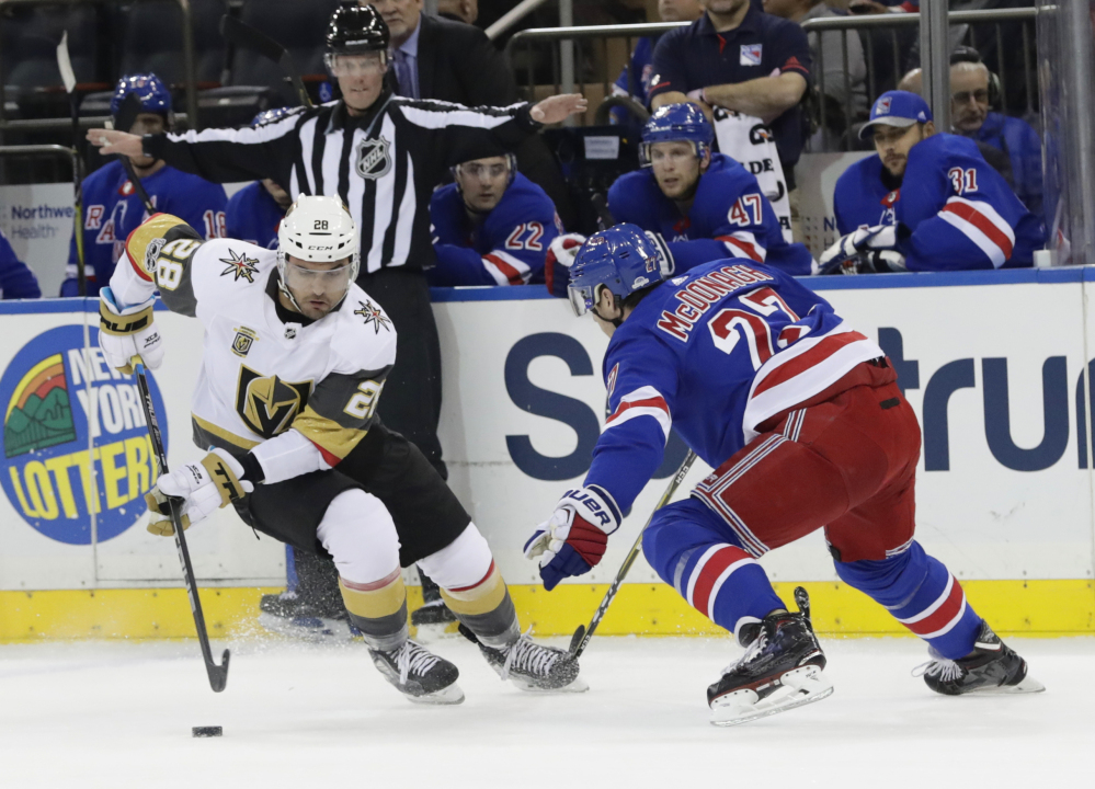William Carrier of Vegas and Ryan McDonagh of the Rangers battle for the puck in Tuesday night's game in New York. The Rangers scored four times in the third period to win 6-4.