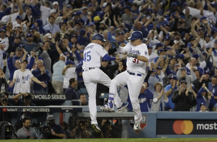 Los Angeles Dodgers' Joc Pederson celebrates his seventh-inning home run with third base coach Chris Woodward. Associated Press/David J. Phillip
