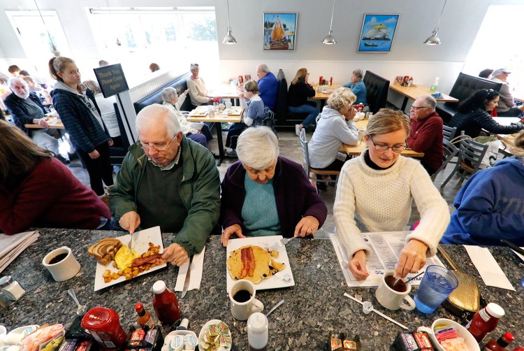 Nelson and Dottie Megna, left, of Portland's Deering neighborhood share a counter at Bernie's Foreside with Diane Thornton-Chandler of Cumberland. All three were without power Tuesday morning. The restaurant has had higher-than-normal volume since the power outages began early Monday morning.