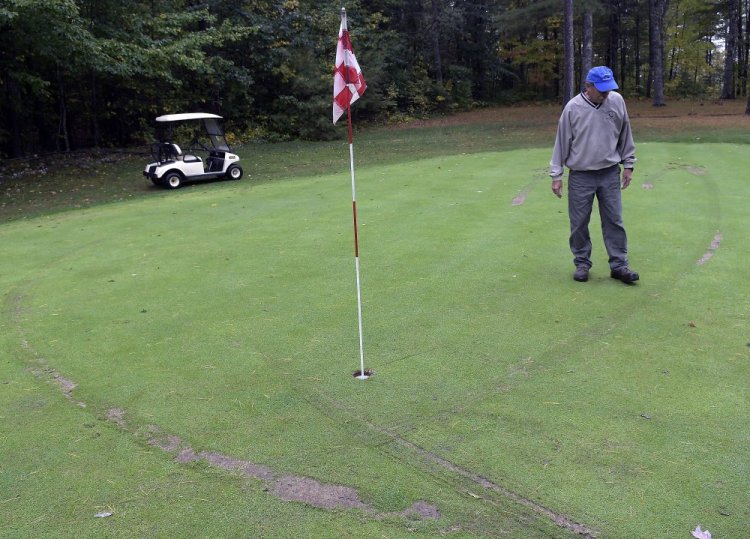 Ruts from golf carts surround Bill Sylvester on the second green at Cobbossee Colony Golf Course in Monmouth on Monday. The Sylvester family discovered Monday that several parts of their course were vandalized by golf carts overnight.