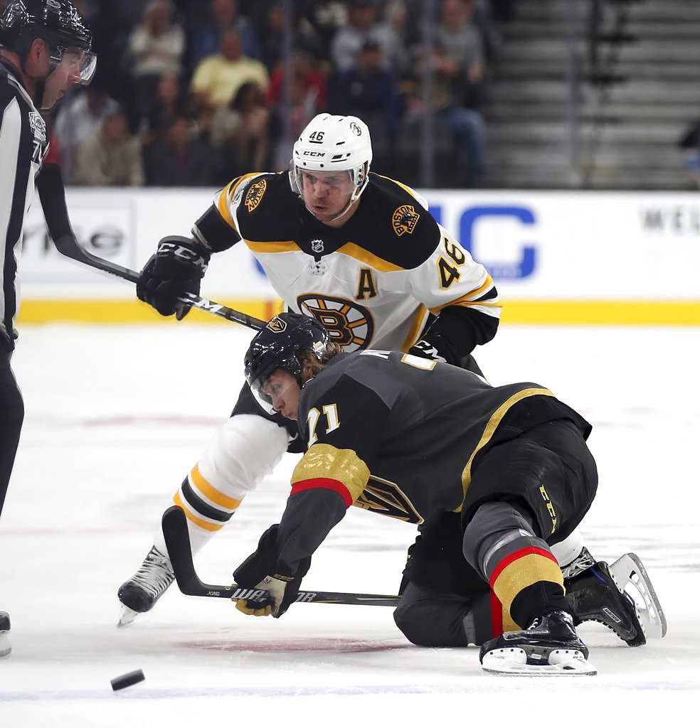 Vegas Golden Knights center William Karlsson goes to the ice to pass a puck away from Boston Bruins center David Krejci during the first period at T-Mobile Arena Sunday in Las Vegas. The Knights defeated the Bruins 3-1. (Associated Press/L.E. Baskow)