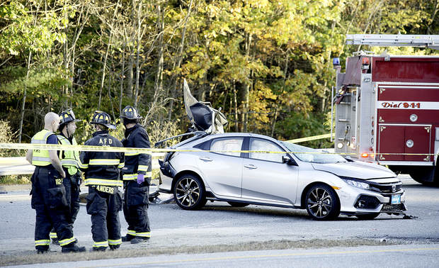 Auburn firefighters stand by after a car and tractor-trailer collided on Washington Street in Auburn on Tuesday. 