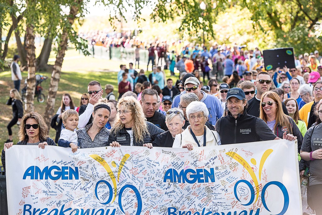 Patrick Dempsey, at the far right, holds the banner at the front of the survivors' walk through Simard Payne Park in Lewiston on Saturday as part of the Dempsey Challenge.