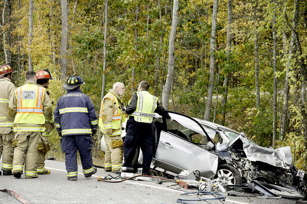 Rescue personnel respond to the fatal crash on Route 136 in Durham on Monday.