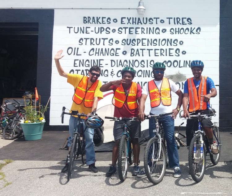 Bikes For All Mainers participants celebrate graduation in July, outside Portland Gear Hub on Washington Ave. From left are instructor John Brooking of the Bicycle Coalition of Maine; Claude Shambare, JOB Mbemba, and Paulo Celestino.
