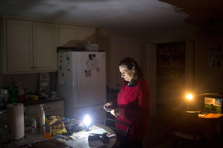 Brenda Sherwin stands in her kitchen in Cumberland at dusk Thursday, illuminated by battery-powered lanterns. She and her husband haven't had power since early Monday morning. Four days isn't the longest they have been out of power. The couple had no power for 10 days after the ice storm in 1998. Sherwin, who does day care in her home, said, "The worst part is not having coffee."