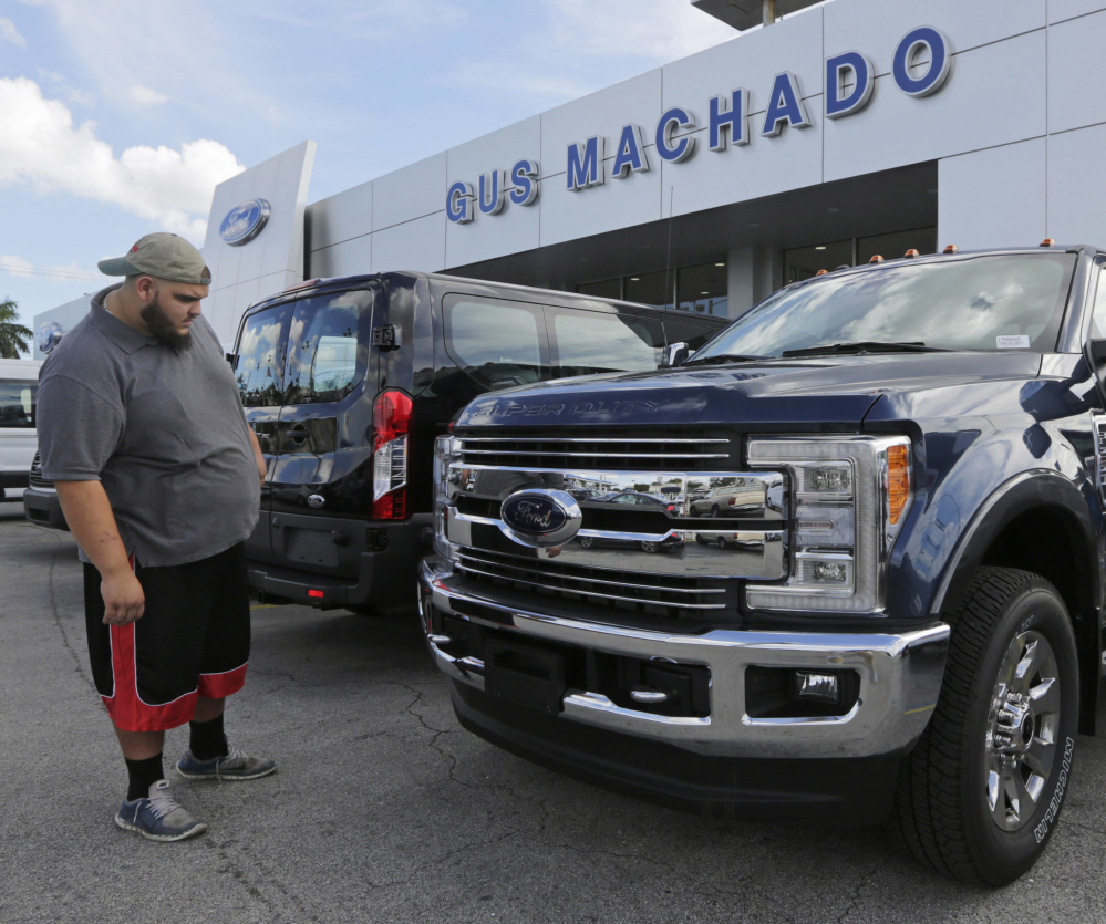 FILE - In this Tuesday, Jan. 17, 2017, file photo, a potential customer looks at a Ford F-250 Lariat FX4 at a Ford dealership, in Hialeah, Fla. Ford posted a big sales jump in October 2017 but Fiat Chrysler and General Motors reported declines as auto companies started to report numbers Wednesday, Nov. 1. The drop by two of the Detroit Three backs analysts' expectations that September's big gain in U.S. auto sales would fizzle in October. (, File)