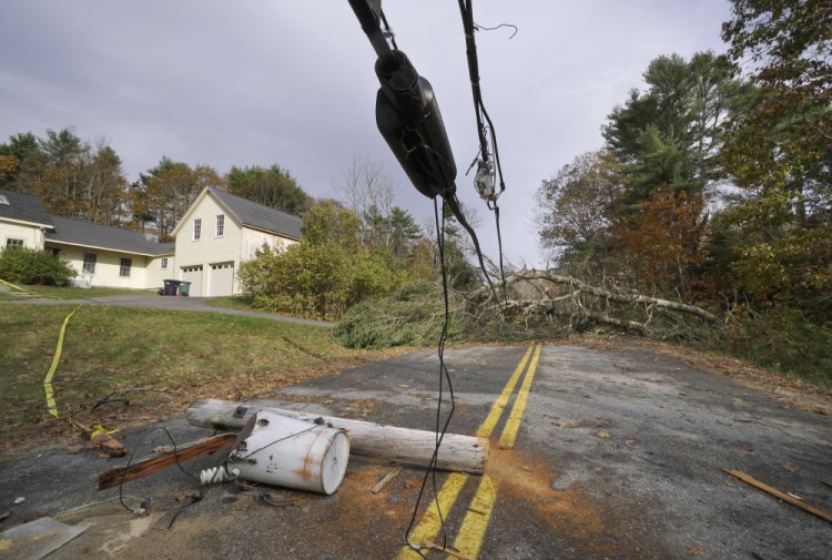 A utility pole with a transformer attached still lies in the middle of Flying Point Road in Freeport, under wires weighted down by trees that block the road, on Nov. 3. The storm that caused the damage left nearly 500,000 Maine electricity customers without power.