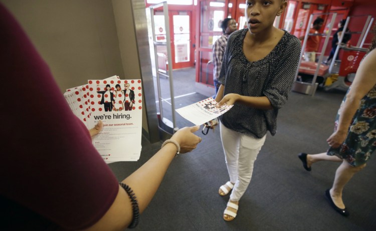 A potential job candidate takes a flyer from a human resources representative at a Target store in Dallas. 