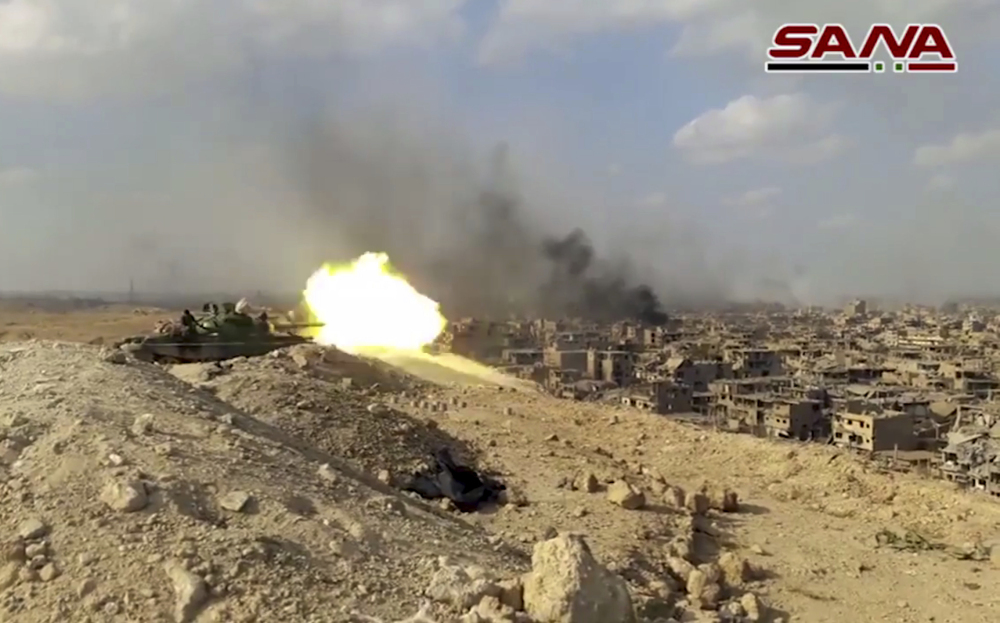 This still from a video released Thursday by the Syrian official news agency SANA shows a Syrian army tank firing during a battle against Islamic State militants in Deir el-Zour, Syria. The Syrian army announced on Friday that it liberated the long-contested eastern city from the Islamic State group.