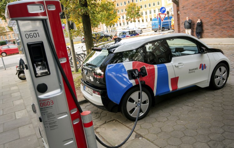 An electric vehicle is connected to a charging station in Hamburg, Germany, last month. Major automakers say their joint European electric-car recharging network will provide a big step toward mass acceptance of battery-powered cars.