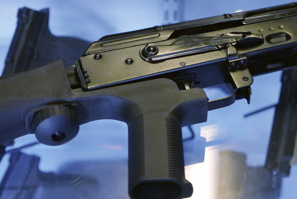 A bump stock is shown attached to a semi-automatic rifle.