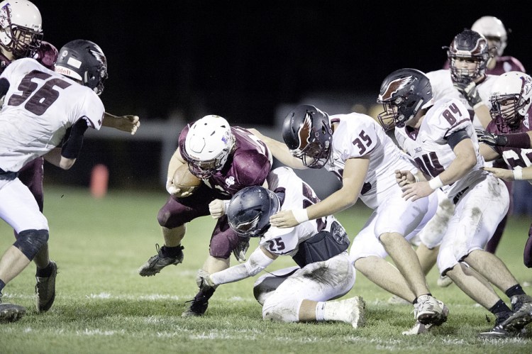 Windham defenders Nathan Watson (25), Logan Emerson (35) and Anthony Kilgallon try to tackle Edward Little's Caden Begos during their Class A North semifinal Friday night in Auburn. Windham beat the top-seeded Red Eddies, 21-12.