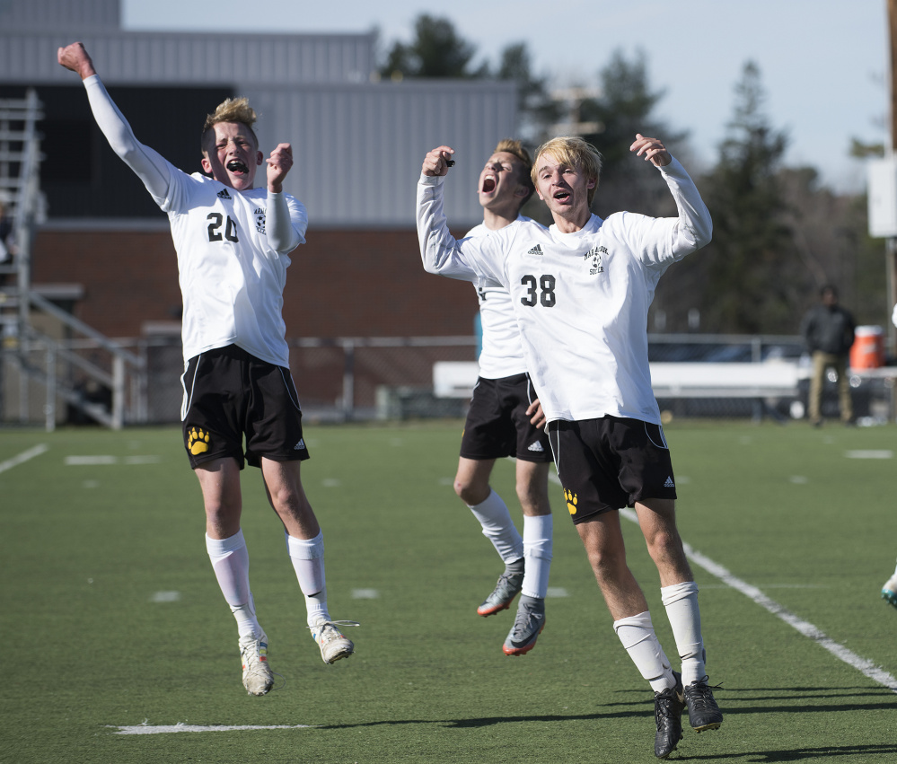 Maranacook players, from left, Duncan Rogers, Wyatt Lambert and Bryan Riley celebrate Silas Mohlar's last-minute goal in the Class C state championship game Saturday against Fort Kent at Hampden Academy. Maranacook won, 1-0.