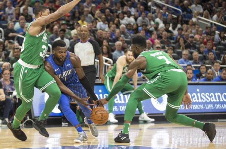 Orlando guard Shelvin Mack has the ball stolen by Celtics guard Jaylen Brown, right, as Boston's Marcus Smart also defends him during the Celtics' 104-88 win Sunday in Orlando, Florida.