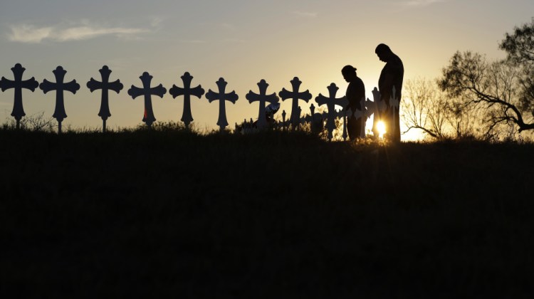 Kenneth and Irene Hernandez pay their respects as they visit a makeshift memorial with crosses placed near the scene of a shooting at the First Baptist Church of Sutherland Springs, Texas, on Monday. In the initial aftermath of Sunday's massacre, officials were searching for answers about how the gunman, Devin Kelley, obtained his weapons.
