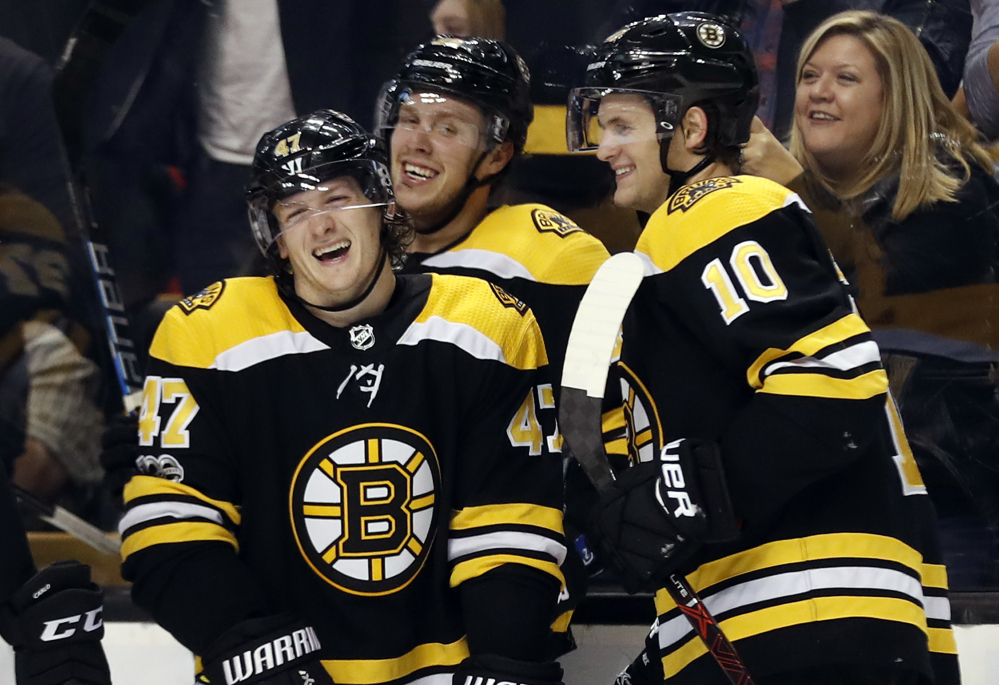 Boston Bruins' Torey Krug (47) laughs with David Pastrnak and Anders Bjork (10) after his goal in the second period.