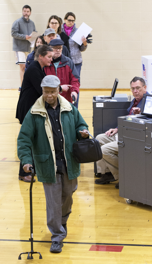 Joseph Kabalda finishes voting Tuesday at Reiche Elementary School in Portland. Residents faced questions on rent limits, zoning reform and school renovations.