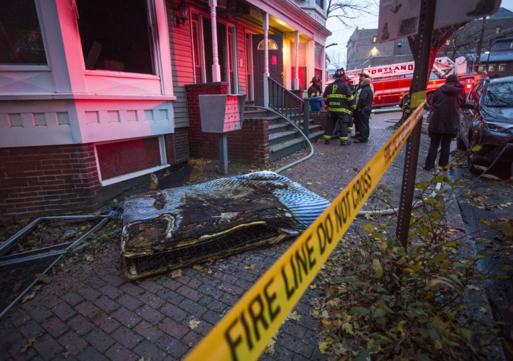 Investigators work Tuesday at 3 Sherman St. in Portland after a fire displaced 13 tenants. One tenant, Peter Sullivan, said he climbed out of his bedroom window to get to safety.