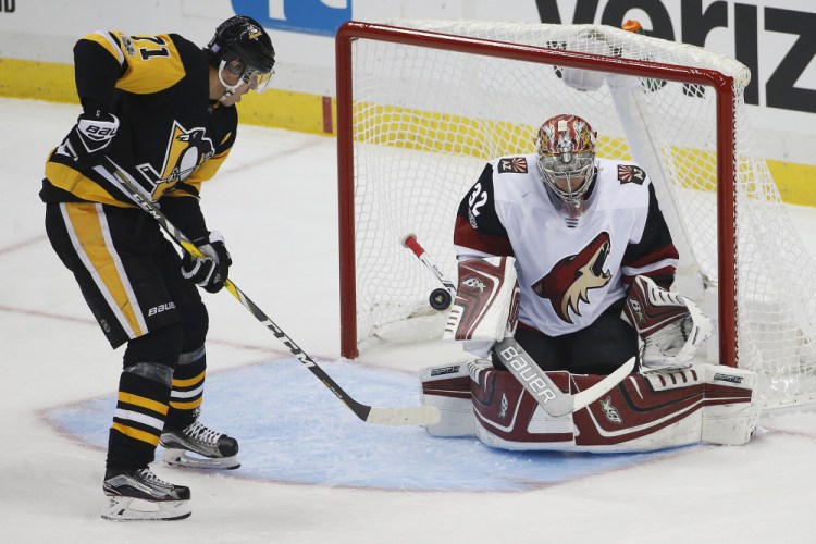 Pittsburgh's Evgeni Malkin deflects a rebound past Arizona goalie Antti Raanta in the first period Tuesday night in Pittsburgh. Malkin also added two assists as the Penguins won 3-1.