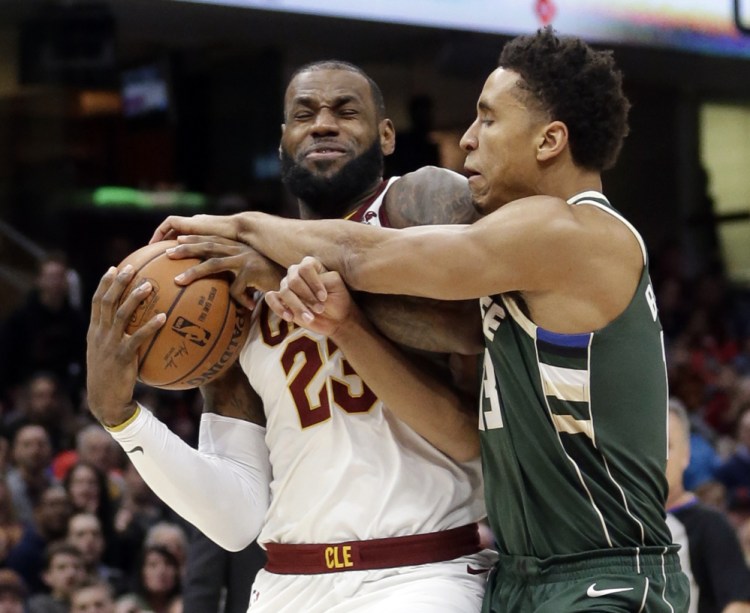 LeBron James, left, of the Cleveland Cavaliers is fouled by Malcolm Brogdon of the Milwaukee Bucks during the first half of Cleveland's 124-119 victory Tuesday night.