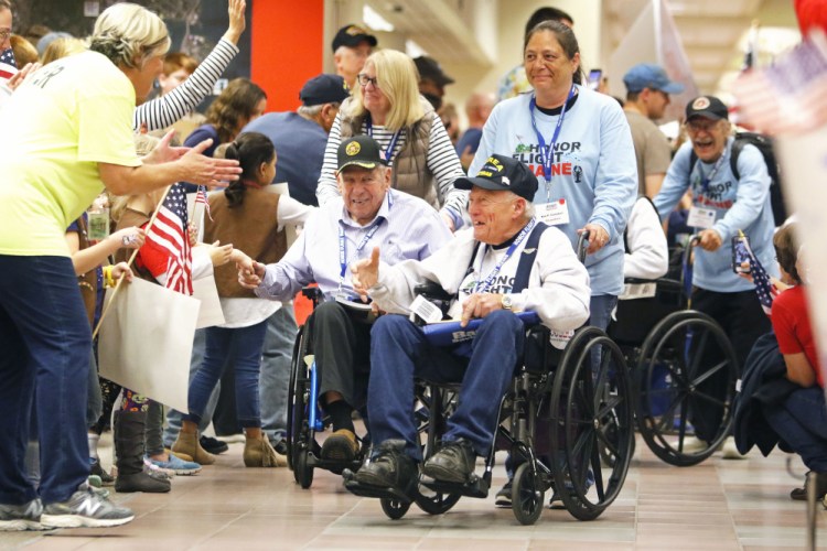 Fanfare greets Maine veterans at the Portland Jetport as they return from an Honor Flight to Washington, D.C.