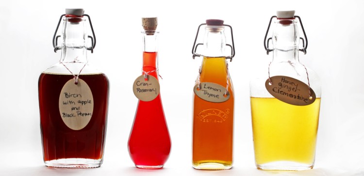 Simple syrups, from left, birch with apple and black pepper, cran-rosemary, lemon thyme, and honey ginger clementine.