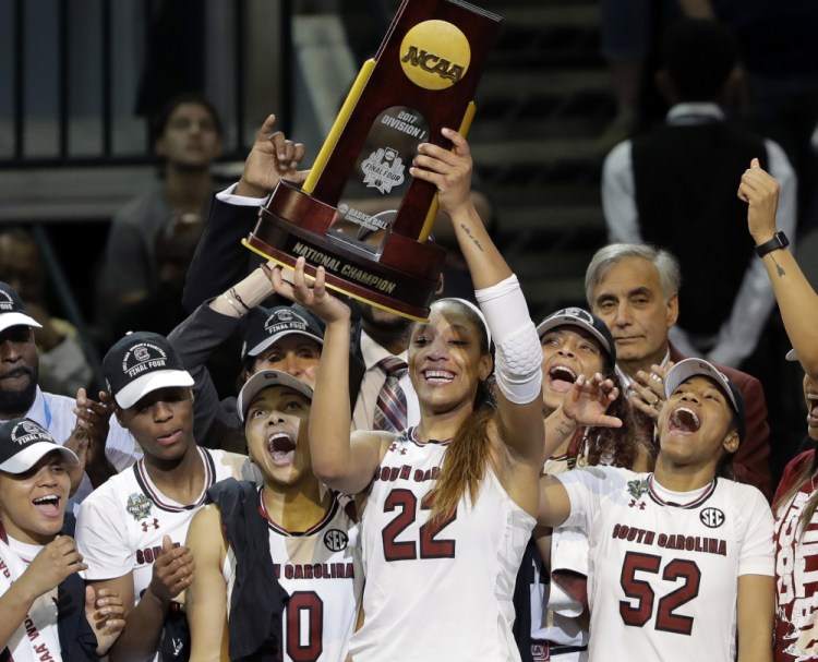 A'ja Wilson, holding last year's NCAA championship trophy, is one of only two returning starters for South Carolina, but the Gamecocks are expected to be strong again.