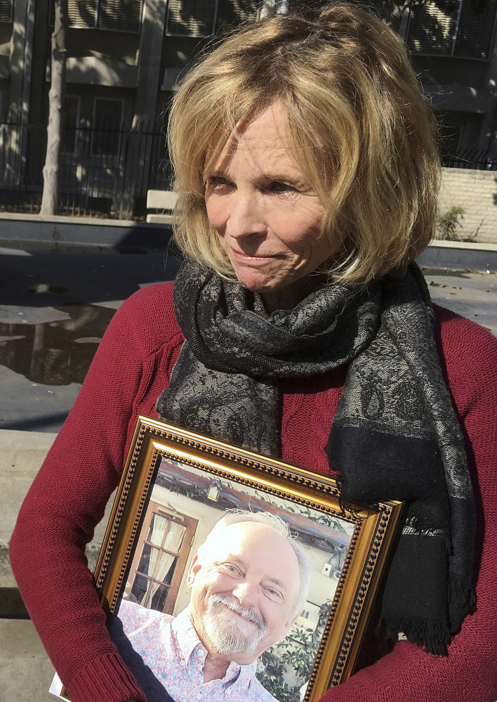 Teri McCall holds a photo of her late husband Jack McCall outside of a courtroom in Fresno, Calif., in January. California can require Monsanto to label its Roundup as a possible cancer threat, a judge tentatively ruled Friday.