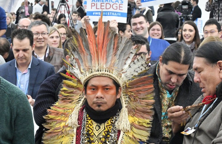 Native Americans wait in the U.S. Climate Action Center for the "America's Pledge" and "We Are Still In" campaign in Bonn, Germany, on Saturday.