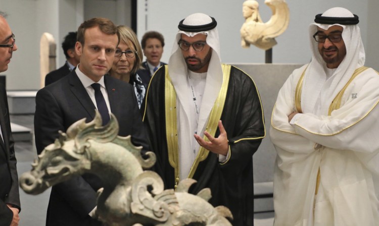 French President Emmanuel Macron, left, with Mohamed Khalifa al-Mubarak and Abu Dhabi Crown Prince Mohammed bin Zayed al-Nahayan, right, visits the Louvre Abu Dhabi Museum on Wednesday. It opened to the public Saturday.