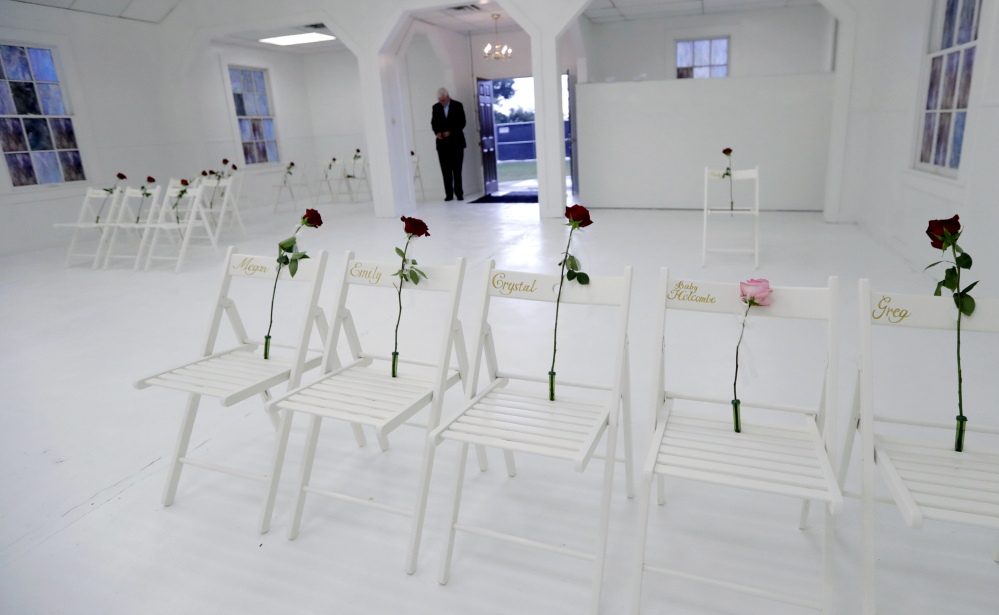 A memorial for the victims of the shooting at Sutherland Springs (Texas) First Baptist Church, including 26 white chairs each painted with a cross and and rose, is displayed in the church Sunday. A man opened fire inside the church in the small South Texas community last week, killing more than two dozen. Associated Press Photo/Eric Gay