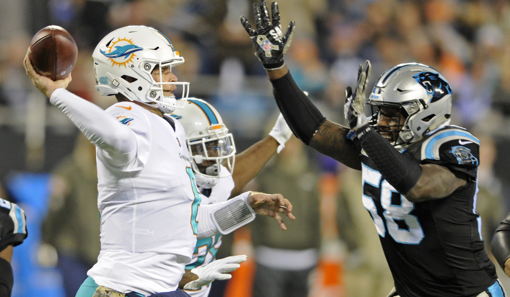 Miami's Jay Cutler tries to get off a pass while Carolina's Thomas Davis closes in during the first half of their game Monday night in Charlotte, North Carolina. Carolina led, 45-14, midway through the fourth quarter.